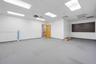 Interior space featuring recessed drop-ceiling lighting, carpeting, a wood-finish interior door, and a horizontal slatted wall accent