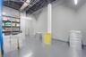 Industrial-style interior featuring high, exposed-truss ceilings, durable epoxy-finish flooring, and built-in metal industrial shelving