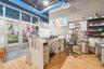 Commercial space featuring wood-finish flooring, floor-to-ceiling glass panel entry doors, exposed industrial-style ceiling with blue ductwork, and bu