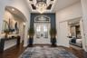 Virtually staged. Foyer featuring wood-finish flooring, a coffered ceiling with a crystal chandelier, arched entryway, and double entry doors with dec