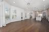 Open floor plan featuring wood-finish flooring, multi-pane windows with plantation shutters, an expansive kitchen island with a neutral countertop, re