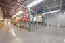 Industrial warehouse interior featuring polished concrete flooring, exposed high-ceiling steel framing, integrated industrial shelving units, and line