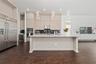 Kitchen featuring floor-to-ceiling cabinetry, a central island with stone countertop, stainless steel double wall ovens, built-in wine refrigeration, 
