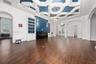 Geometric coffered ceiling with inset blue accents, wood-finish flooring, built-in floor-to-ceiling cabinetry, shiplap fireplace surround, and modern 