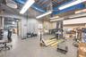 Industrial space featuring high ceilings with exposed ductwork, fluorescent lighting, concrete flooring, and built-in upper cabinetry
