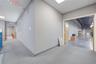 Commercial interior featuring neutral-toned walls, industrial-style exposed ceiling beams, polished concrete flooring, drop ceiling panels, and wood-v