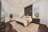 Virtually staged. Tray ceiling with a central pendant light, wood-finish flooring, charcoal horizontal plank accent wall, and dual floating bedside dr