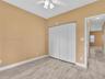 Room featuring wood-finish flooring, a white three-blade ceiling fan with integrated light fixture, and a white bifold closet door