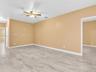 Spacious interior featuring large-format tile flooring and a ceiling-mounted light fixture with a fan