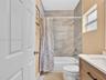 Bathroom featuring a vanity with a light wood-finish cabinet, white countertop, integrated sink, and polished chrome fixtures, accented by neutral-ton