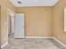 Neutral-toned interior space featuring stone-finish tile flooring, solid-core interior doors, and closet doors with louvered panels