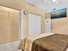 Interior space featuring wood-finish flooring, white bifold closet doors, and white multi-panel interior doors