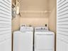 Laundry area featuring louvered bifold doors and built-in wire shelving