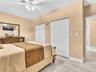 Room featuring wood-finish flooring, dual bi-fold door closets, and a ceiling-mounted fan with integrated lighting