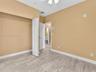 Neutral-toned interior space featuring light-colored wood-finish flooring, a bi-fold closet door, and a ceiling-mounted light fixture