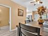 Wood-finish flooring throughout, ceiling-mounted light fixture with integrated fan, and built-in stainless steel kitchen appliance