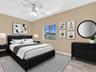Neutral interior with light-toned wood-finish flooring, white ceiling fan with integrated lighting, and slider-style window