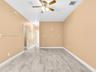 Interior space featuring wood-finish flooring, neutral wall tones, and a ceiling fan with integrated light fixtures