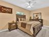 Tile flooring with a wood-finish, neutral wall paint, and a central ceiling fan with integrated lighting