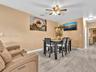 Ceramic tile flooring, neutral wall tones, and ceiling-mounted light fixture with a multi-blade fan