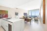 Center island featuring a white stone countertop, undermount sink, and integrated wine refrigeration, complemented by large-format tile flooring and f