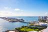 High-altitude perspective featuring expansive water, cityscape, harbor, and parkland surroundings