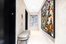 Hallway featuring smooth textured wall finishes, solid-core black paneled doors, and polished stone flooring