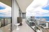 Expansive wrap-around balcony featuring large-format tile flooring, a curved architectural design, and floor-to-ceiling glass paneling with metal rail