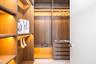 Custom walk-in closet featuring wood-finish cabinetry, built-in shelving, integrated lighting, and a multi-drawer storage unit