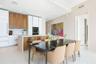 Modern kitchen featuring two-tone cabinetry with wood-finish uppers and white flat-panel base cabinets, central island with waterfall-edge countertop,