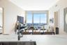 Stone countertop with an undermount sink, chrome gooseneck faucet, and floor-to-ceiling glass panel windows