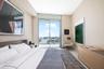 Floor-to-ceiling glass sliding door, balcony with metal railing, and neutral wall tones