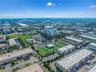 Aerial perspective of commercial complex, paved parking areas, and surrounding professional buildings