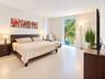 Spacious room featuring neutral tile flooring, floor-to-ceiling window, and natural illumination