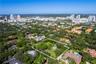 Aerial perspective featuring a large, irregularly shaped lot with mature trees and expansive green space