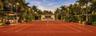Professional-grade clay tennis court featuring perimeter post lighting, a private covered viewing pavilion, mature perimeter landscaping, and a detach