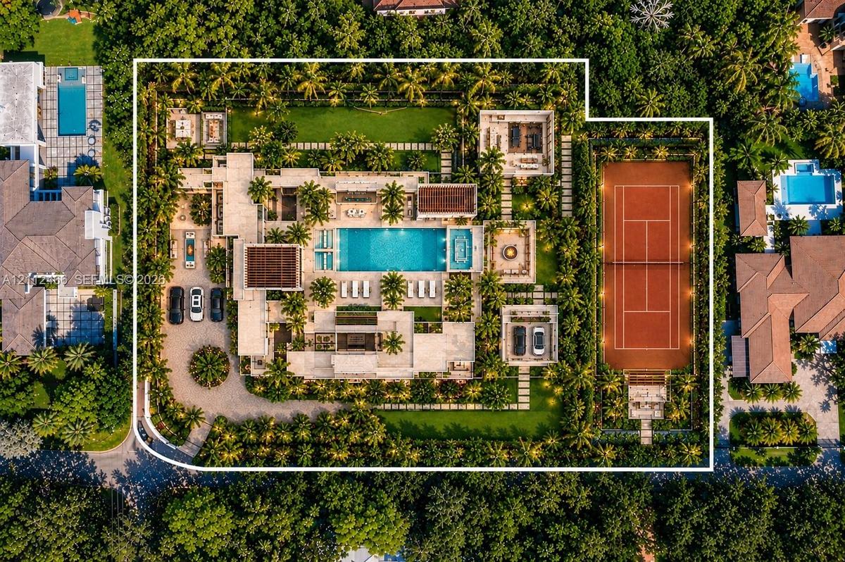 Aerial perspective of a sprawling estate featuring a clay tennis court, large swimming pool with built-in spa, expansive manicured grounds, covered pa