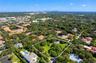 Aerial perspective of a sprawling property featuring expansive open grounds, mature canopy trees, and an integrated swimming pool