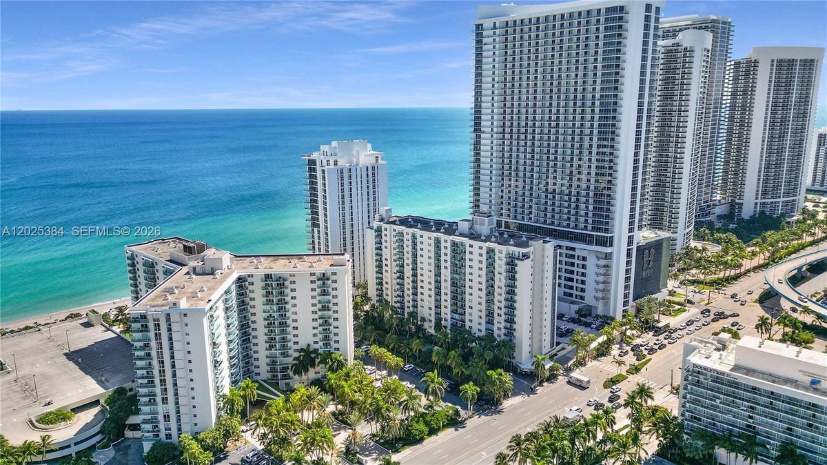 High-rise residential towers featuring private balconies, proximity to the coastline, and mature palm landscaping