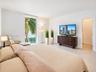 Neutral-toned interior featuring large-format tile flooring, a vertical picture window, and a built-in walk-in closet