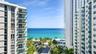 High-rise exterior featuring stacked balconies with glass railings and unobstructed ocean frontage