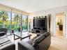 Floor-to-ceiling sliding glass doors, balcony with glass railing, and large-format tile flooring