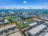 Aerial perspective of a commercial property featuring a private surface parking lot, paved exterior grounds, and proximity to major regional thoroughf
