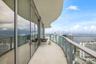 Expansive curved balcony featuring floor-to-ceiling glass paneling, metal railings, and stone-finish flooring