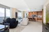 Floor-to-ceiling windows, custom wood-finish cabinetry, built-in panel-ready appliances, stone-topped kitchen island, and large-format tile flooring