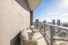 Private balcony featuring a curved wall, neutral-toned flooring, and a glass-paneled railing with a metal frame