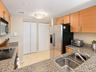 Kitchen featuring light-finish cabinetry, stone countertops, stainless steel appliances, dual-basin stainless steel sink, and tile flooring