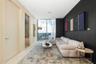 Floor-to-ceiling windows, matte black accent wall, and polished stone-finish flooring