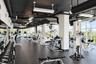 Fitness center featuring industrial-style exposed ceiling, rubberized flooring, expansive floor-to-ceiling windows, and wall-to-wall mirrors