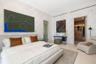 Bedroom featuring textured wall covering, recessed ceiling track lighting, and a walk-in closet with built-in cabinetry
